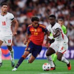 Un jugador de España avanza con el balón frente a un defensor de Inglaterra en Wembley.