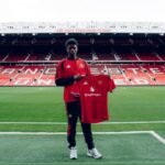Karim Cassim sostiene una camiseta del Manchester United en Old Trafford