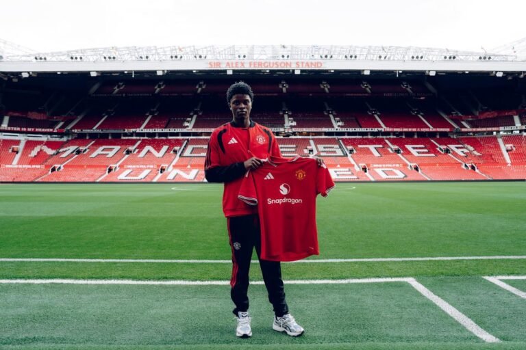 Karim Cassim sostiene una camiseta del Manchester United en Old Trafford