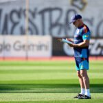 Miembro del cuerpo técnico de España consulta unos papeles en un campo de entrenamiento