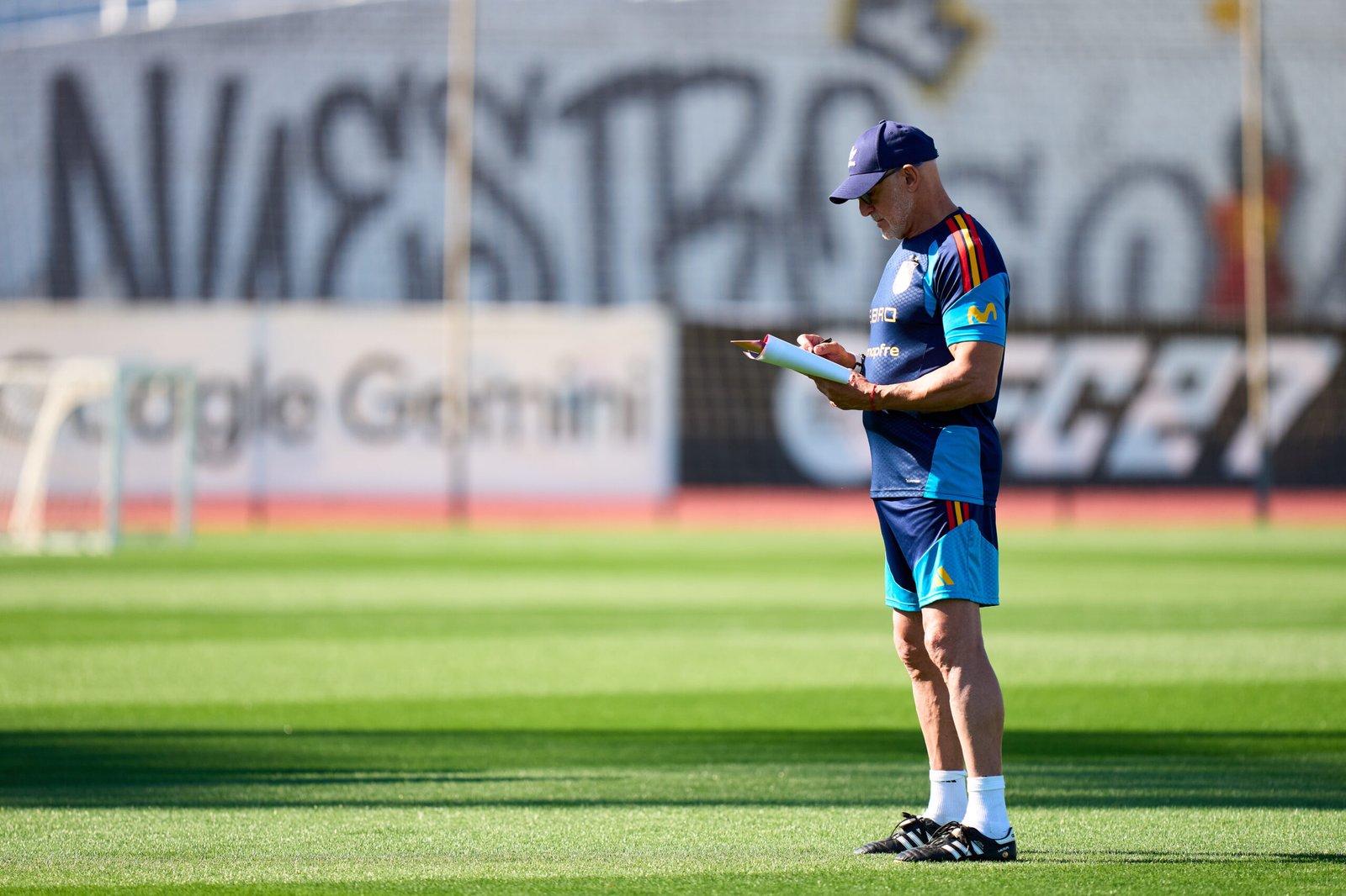 Miembro del cuerpo técnico de España consulta unos papeles en un campo de entrenamiento