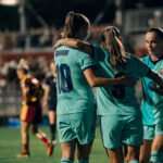 Graham Hansen se abraza a una compañera del Barcelona ante una tercera jugadora durante el partido frente a la Roma.