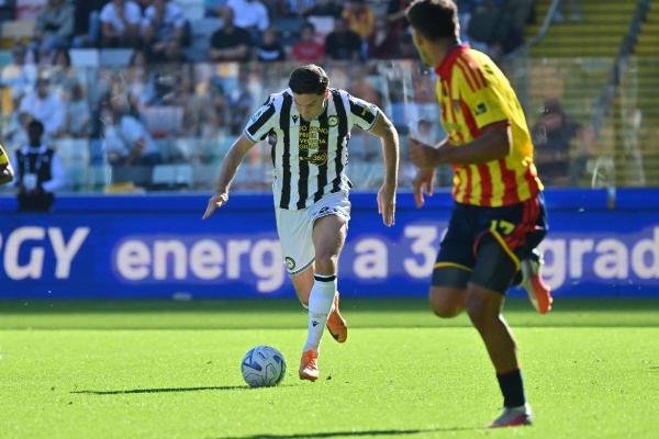 Un futbolista del Udinese conduce el balón ante un jugador del Lecce