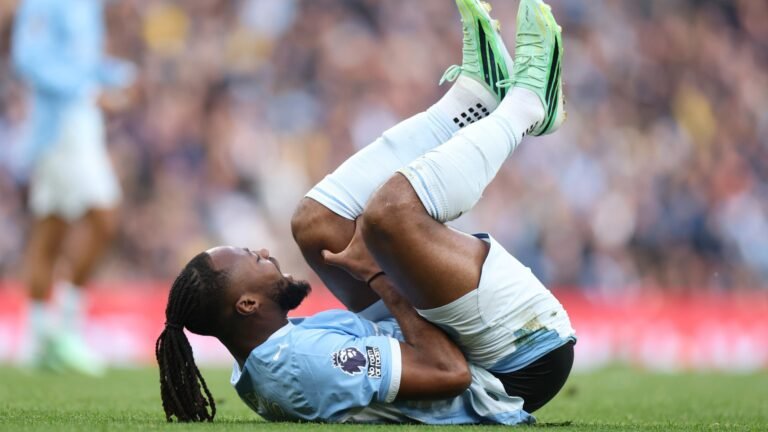Antoine Semenyo, tendido sobre el césped con la camiseta del Manchester City.