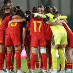 Jugadoras de España sub-17 abrazadas en círculo sobre el césped