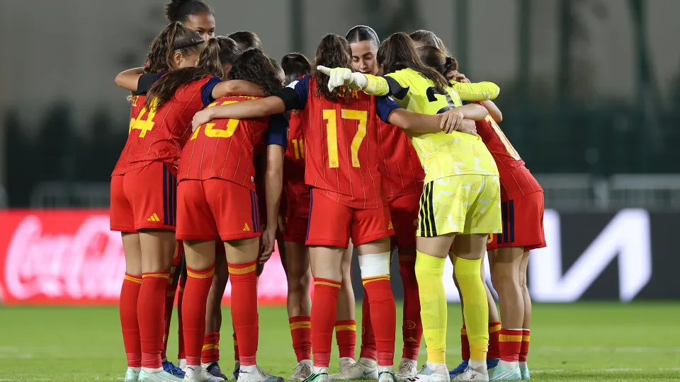 Jugadoras de España sub-17 abrazadas en círculo sobre el césped