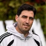 Andoni Iraola, con una chaqueta clara, mira hacia la cámara.