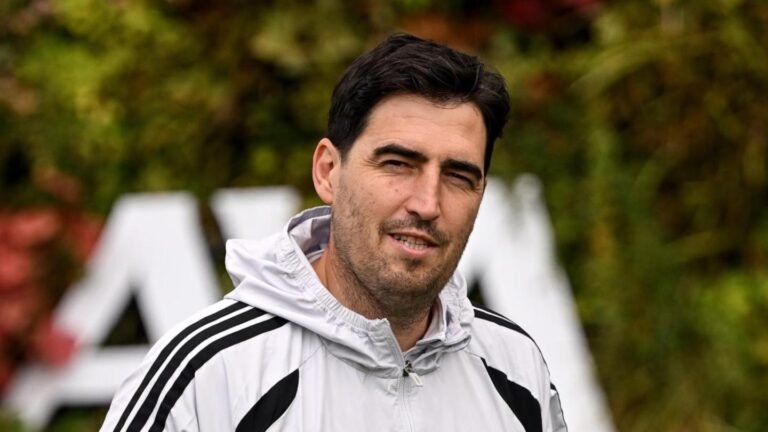 Andoni Iraola, con una chaqueta clara, mira hacia la cámara.