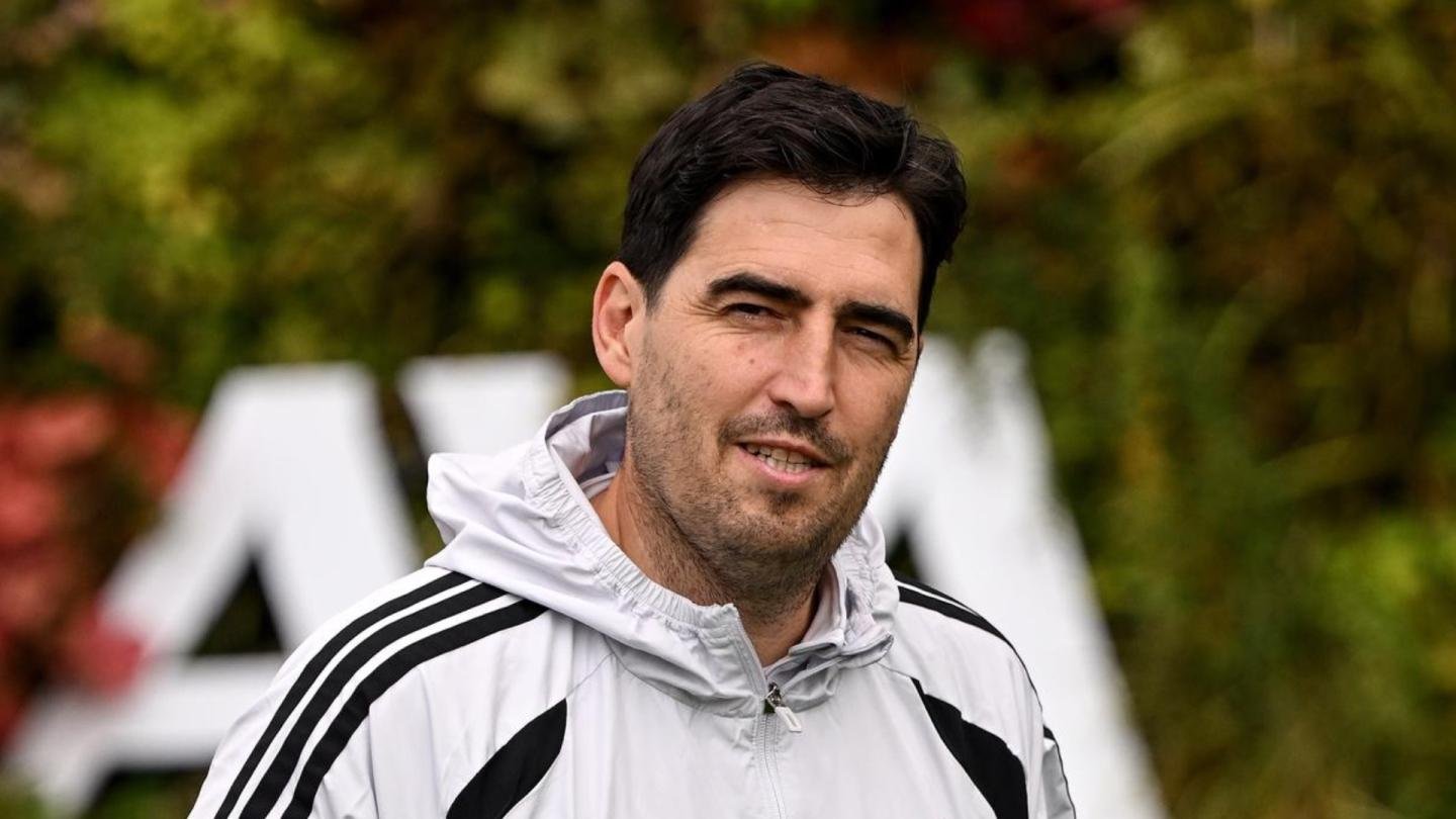 Andoni Iraola, con una chaqueta clara, mira hacia la cámara.