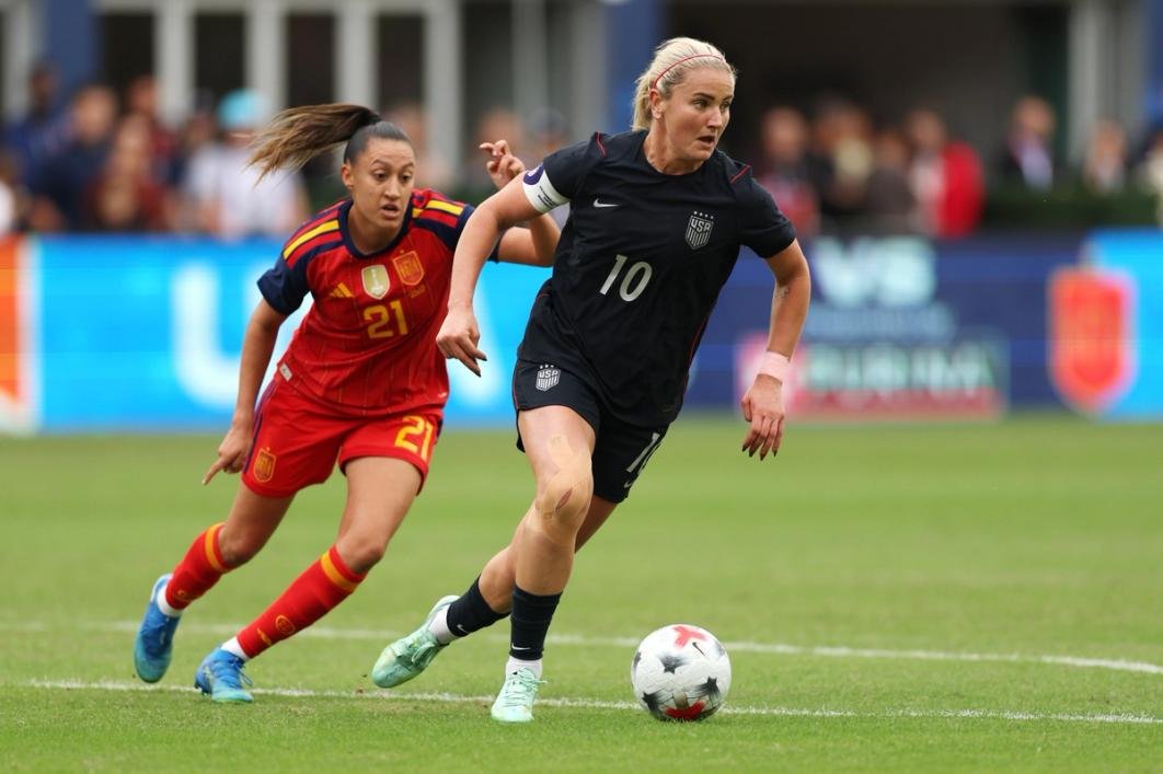 Futbolista estadounidense con el balón ante una jugadora de España