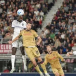 Un jugador del Inter salta para disputar un balón aéreo ante futbolistas del Bologna.