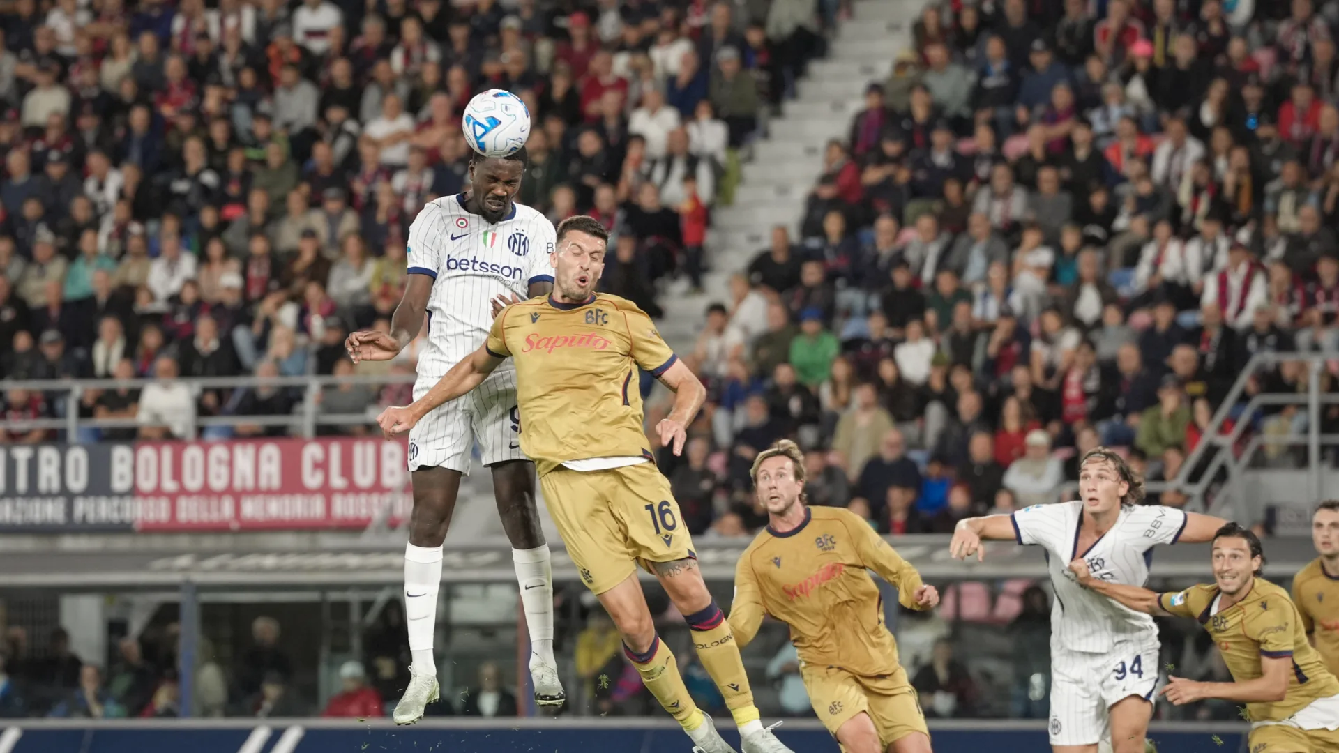Un jugador del Inter salta para disputar un balón aéreo ante futbolistas del Bologna.