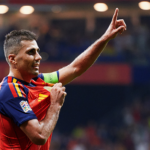 Futbolista de España con brazalete de capitán y un brazo levantado durante el partido en Oviedo